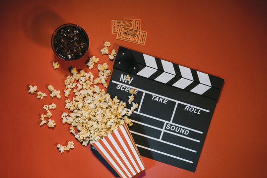 Watching Movie With Popcorn On Red Background Top View.