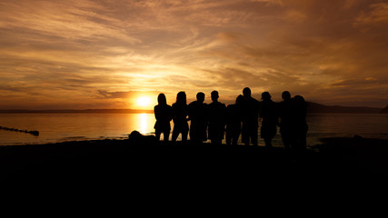 Black silhouette of a crowd of people at sunset