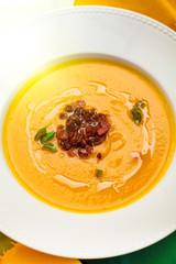 beautiful flow, pumpkin soup with fried bacon, close-up, restaurant