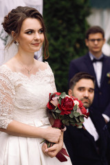 Bride and groom on the wheelchair hold their hands together standing before the altar