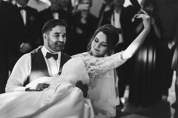 Bride and groom on the wheelchair dance for the first time in the restaurant hall