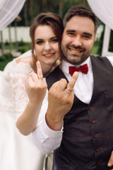 Happy bride and groom on the wheelchair show their wedding rings