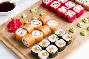 Set of different types of Japanese sushi rolls on wooden Board