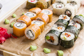 Set of different types of Japanese sushi rolls on wooden Board