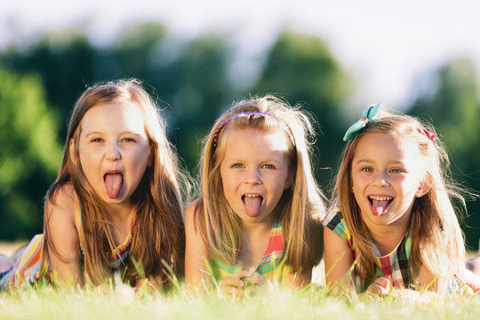 Three little girls sticking their tongues out