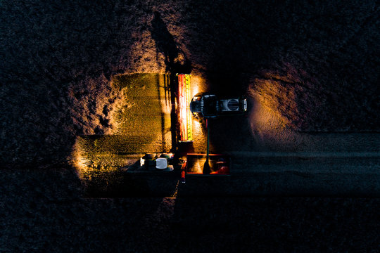 Combine Working On The Field In The Night