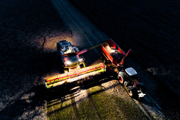 Combine working on the field in the night - obrazy, fototapety, plakaty
