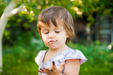 Painting. little girl is drawing. Young artist.  Funny girl  in the park.  activity for children.  funny girl painted her face. Dirty face
