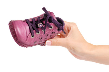 Children's pink shoe in hand on a white background isolation