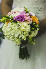 Bridal bouquet held by her with her hands at her wedding