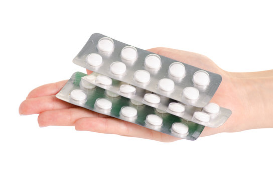Medicine pills in blister, drug tablets in hand isolated on white background. Pharmacy and medication.