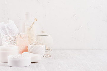 White delicate cosmetics products for body and skin care in white modern bathroom on shelf, copy space.