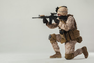 Soldier in camouflage holding rifle