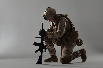 Soldier in camouflage holding rifle