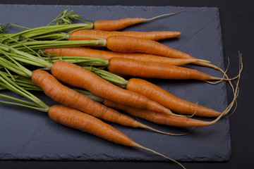 Carrots with leafs on grey background