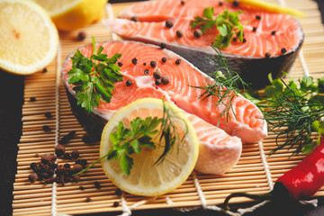 Salmon steaks with lemon and spices close up view