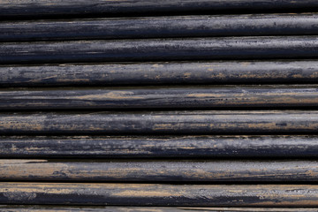 Oil Drill pipe. Rusty drill pipes were drilled in the well section. Downhole drilling rig. Laying the pipe on the deck. View of the shell of drill pipes laid in courtyard of the oil and gas warehouse.