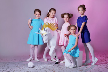 Group little girl in beautiful pink,blue dresses next with unicorn figure. Five lady children...