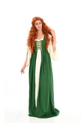 full length portrait of red haired girl wearing long green medieval gown. standing pose, isolated on white studio background.