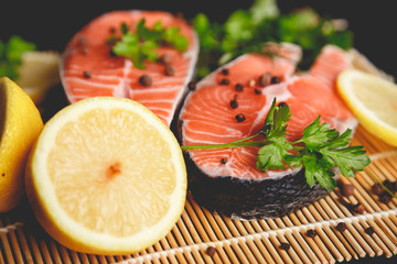 Salmon steaks with lemon and spices close up view.