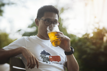 Fototapeta premium Young spectacled man drinking beer.