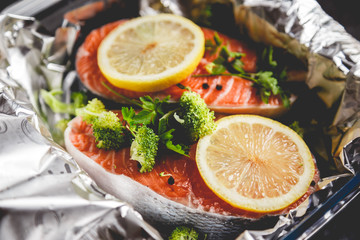 Raw sockeye salmon steaks on foil before baking in oven