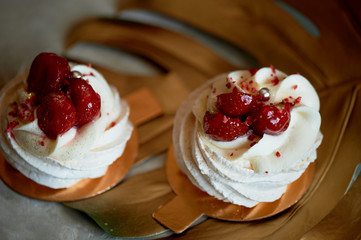 Airy and delicious meringue Anna Pavlova on a gold leaf monstera. Culinary art