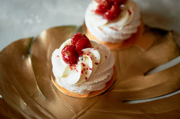 Airy and delicious meringue Anna Pavlova on a gold leaf monstera. Culinary art