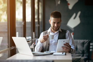Young businessman working on a plan of Internet project on the laptop. Man discusses business matters by phone. Working computer for internet research. Digital marketing. Development