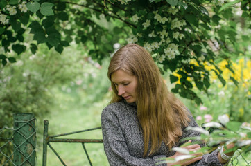 Portrait of a melancholy woman with long hair against a nature background