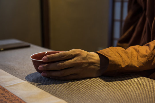 A monk is drinking tea