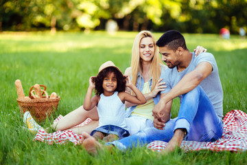 Picture of lovely couple with their daughter having picnic