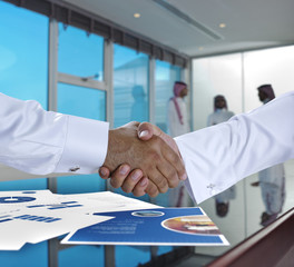 Saudi Arab businessmen shaking hands, and making agreement or a deal