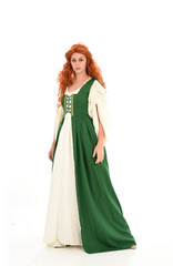 Fototapeta premium full length portrait of red haired girl wearing long green medieval gown. standing pose, isolated on white studio background.