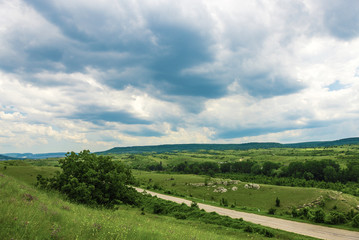 Road between green hills and
