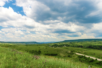 Road between green hills and