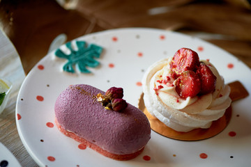 Fruit mousse cake and meringue Anna Pavlova on beautiful saucers. Culinary art.