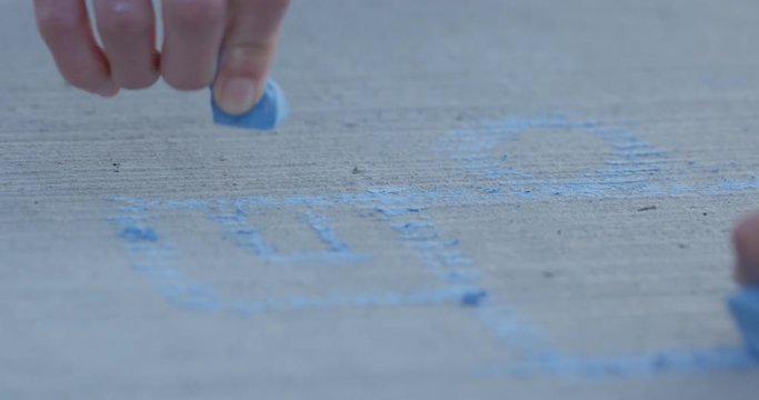Childs drawing house on sidewalk with sidewalk chaulk - family fun