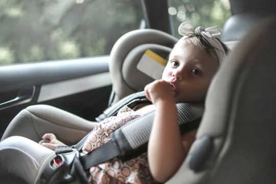 Cute Baby Sitting On The Booster Seat In The Car