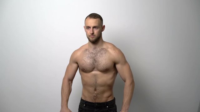 Slow motion video of a shirtless muscular man training with Resistance Band