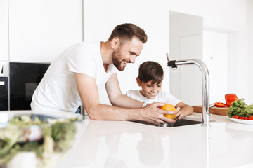 Cheerful young man father dad cooking with his son