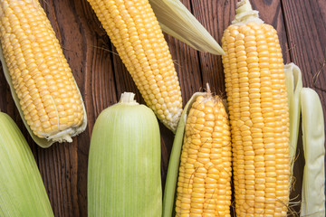Fresh organic yellow sweet corn on wooden table. Top view.
