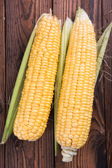 Fresh organic yellow sweet corn on wooden table. Top view.