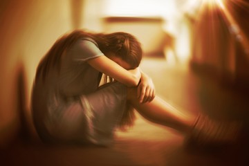 Sad schoolgirl sitting in corridor