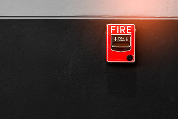 Fire alarm on black and white concrete wall. Warning and security system. Emergency equipment for...