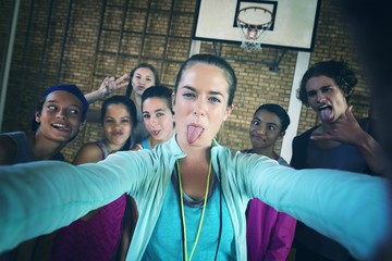 Female coach and high school kids taking a selfie