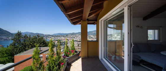 Balcony with large window. View on the city and the lake.