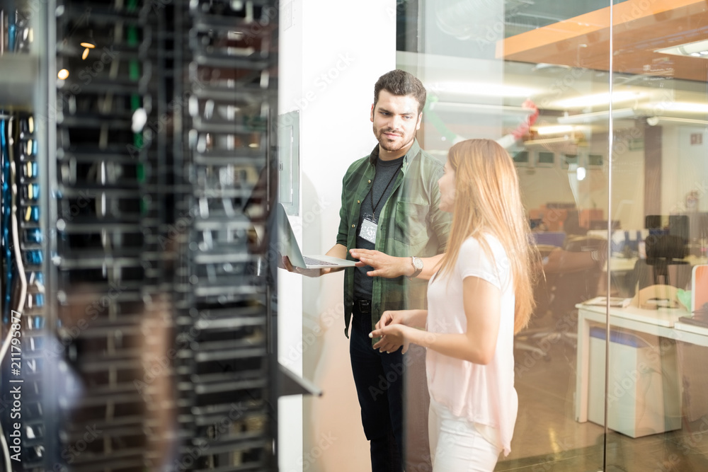 Wall mural Colleagues discussing in office server room