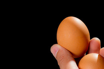 Eggs in hand, black background,  food organic