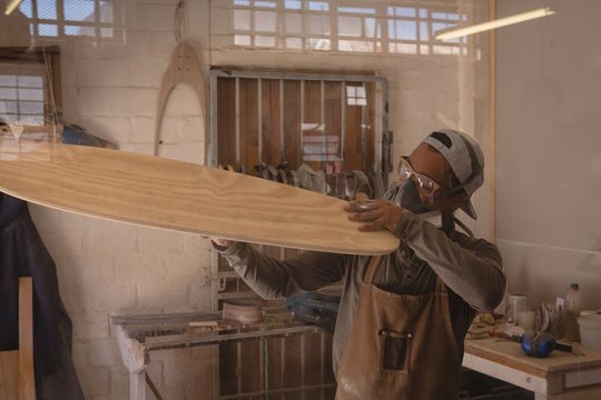 Man examining a skateboard in workshop